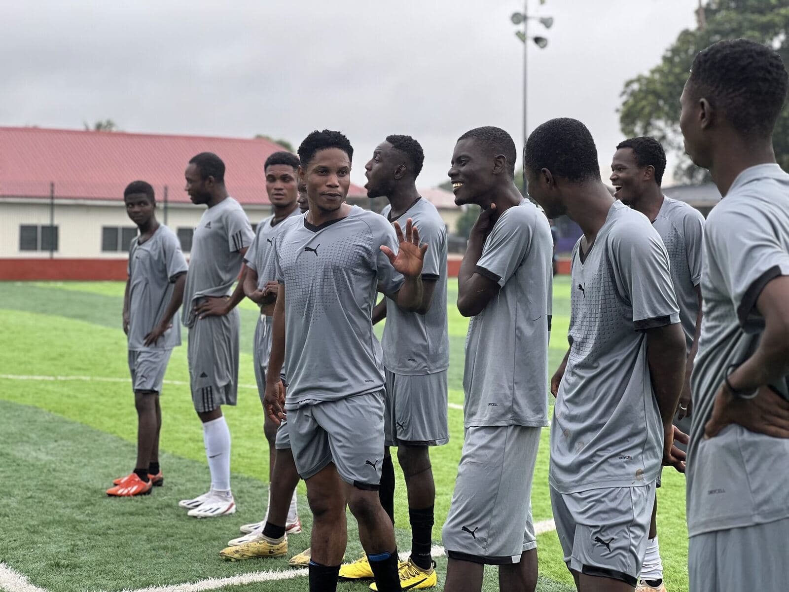 Players in grey laughing together on the pitch