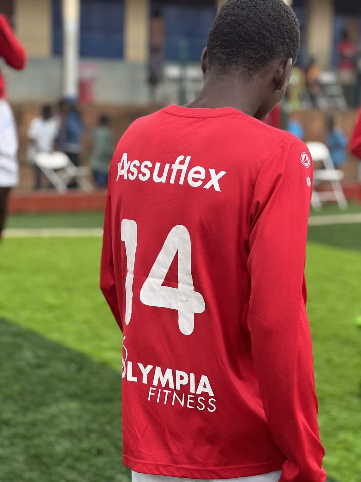 Player in a red shirt with Belgian sponsors