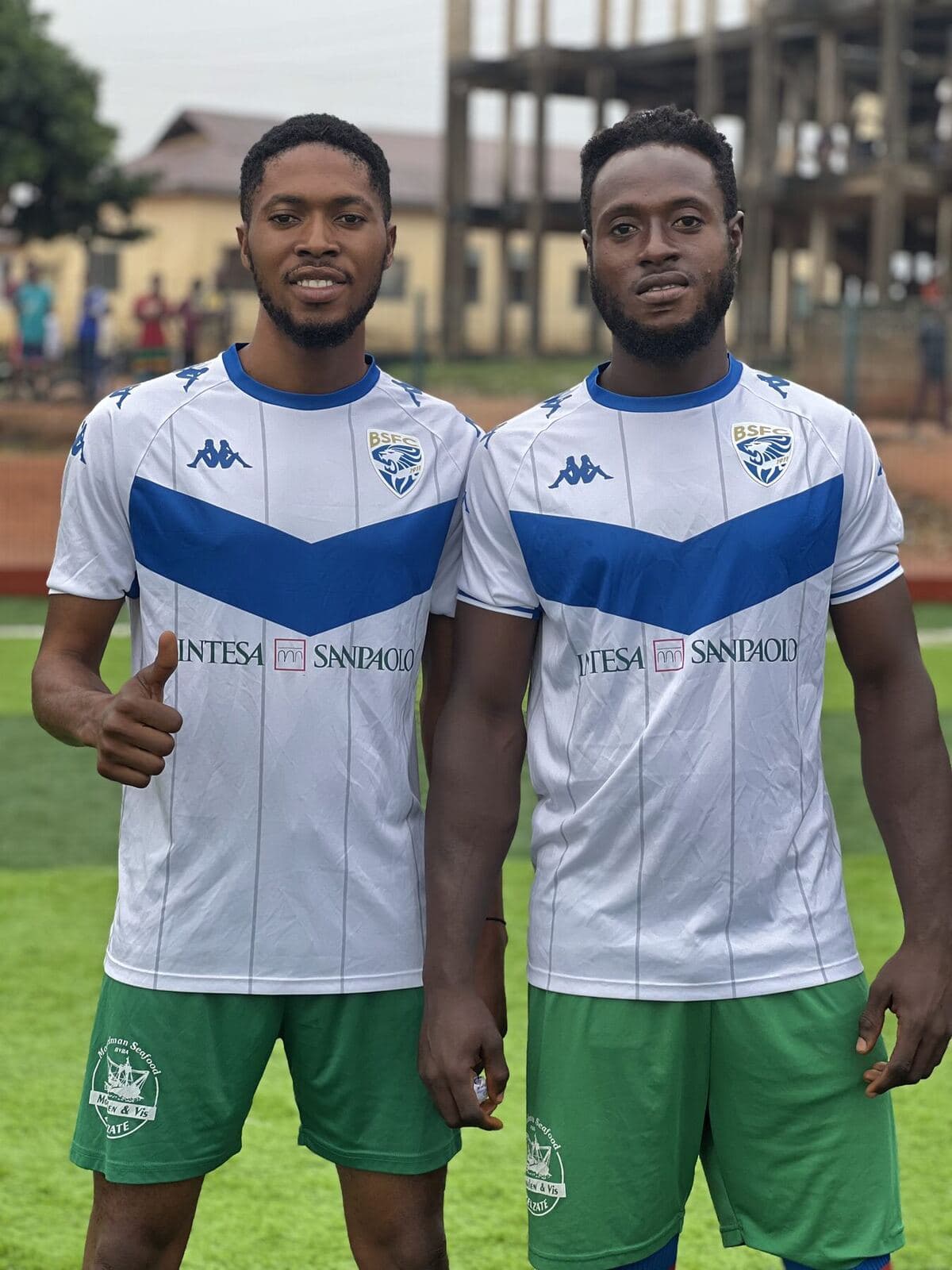 Two players in white and green giving a thumbs up