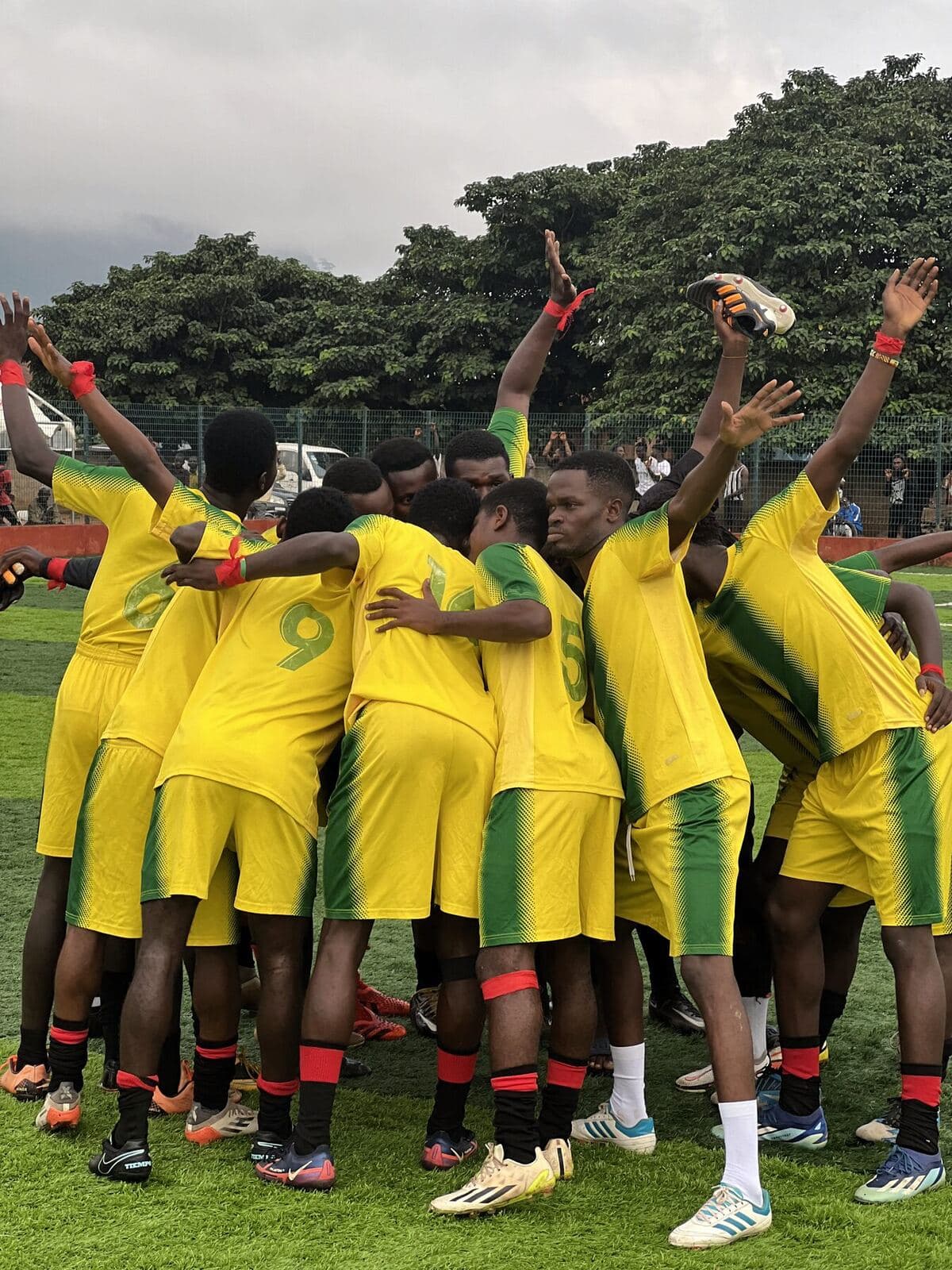 Team in yellow and green celebrating in a huddle