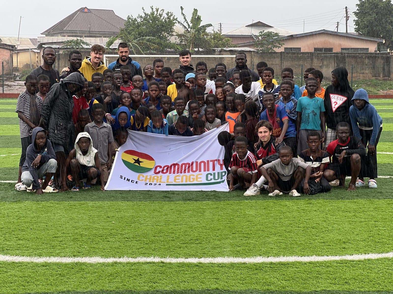 Players, children and coaches together behind the Community Challenge Cup banner